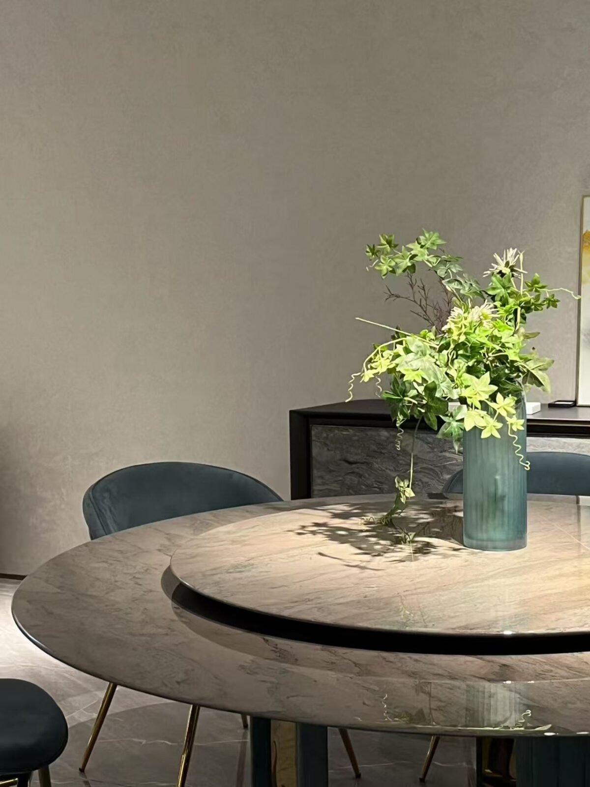 Close-up of Tianshan snow stone surface with natural veining and smoked glass turntable on luxury table