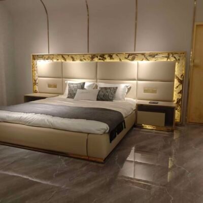 Luxury bed with gold headboard and smart lighting in modern bedroom with matching nightstand
