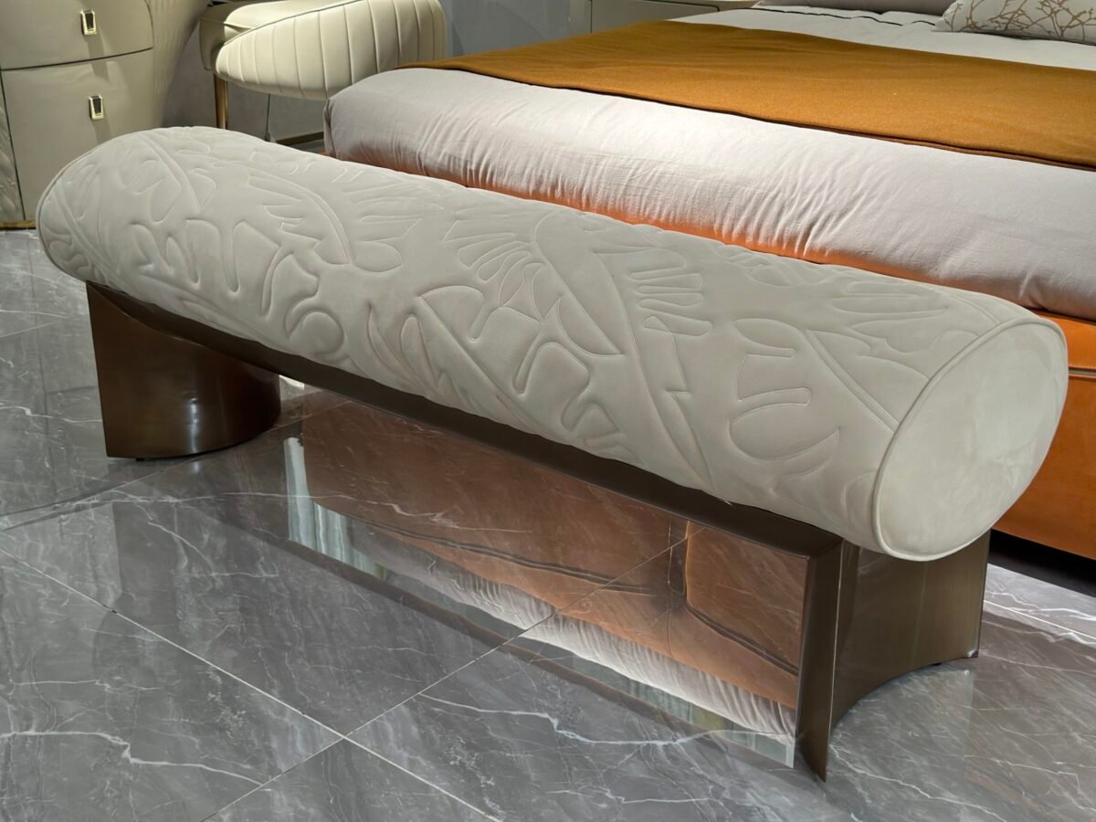 Hotel bedroom stool at foot of king-size bed in luxury boutique hotel suite