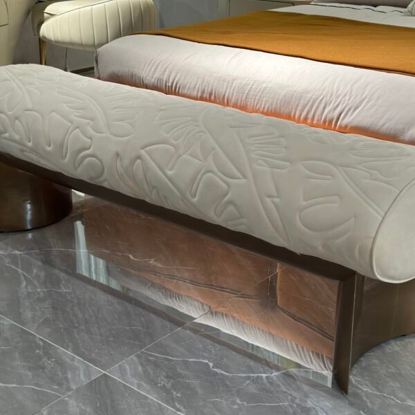 Hotel bedroom stool at foot of king-size bed in luxury boutique hotel suite