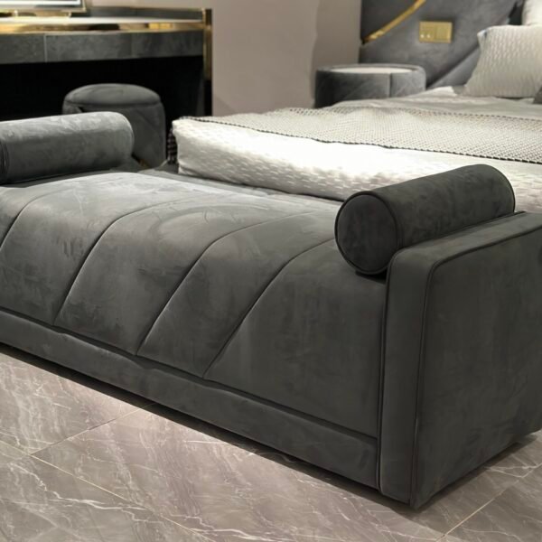 Luxury bedroom bench with armrests at foot of king-size bed in boutique hotel suite