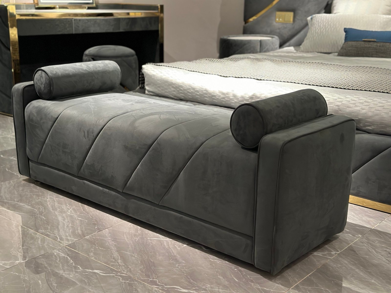 Luxury bedroom bench with armrests at foot of king-size bed in boutique hotel suite