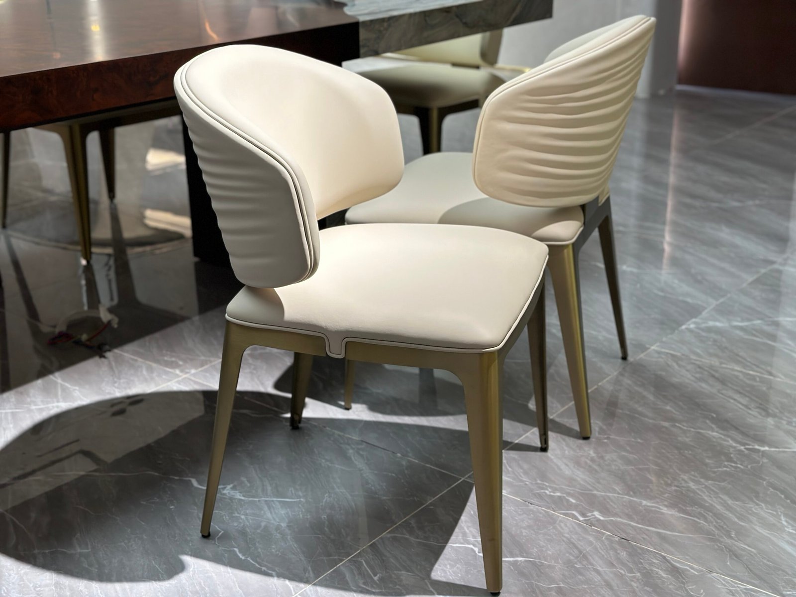 Titanium finish dining chair detail showing brushed metal texture leather upholstery close-up