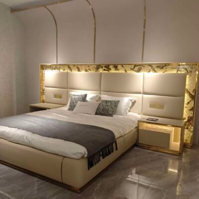 Luxury bed with gold headboard and smart lighting in modern bedroom with matching nightstand