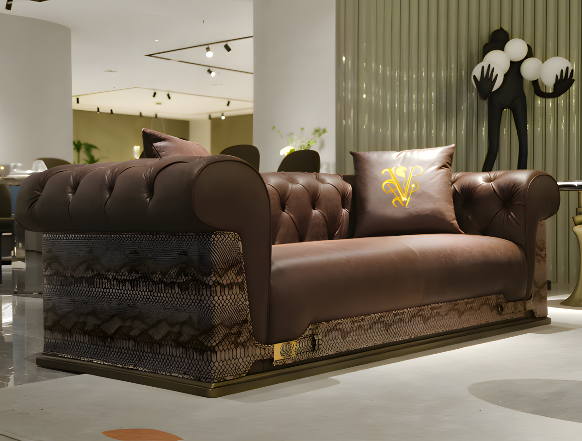 Close-up snakeskin trim and gold lettering detail on brown waxed genuine leather sofa