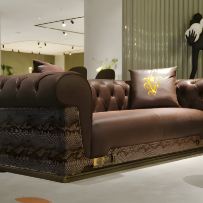 Close-up snakeskin trim and gold lettering detail on brown waxed genuine leather sofa