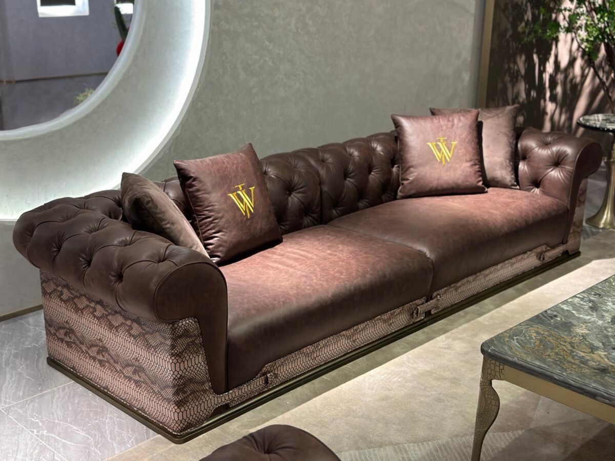 Close-up snakeskin trim and gold lettering detail on brown waxed genuine leather sofa