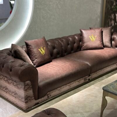 Close-up snakeskin trim and gold lettering detail on brown waxed genuine leather sofa