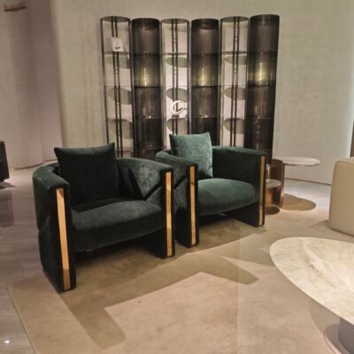 Green velvet accent chair boutique hotel bedroom interior luxury furniture hospitality design gold trim contemporary glamour setting.