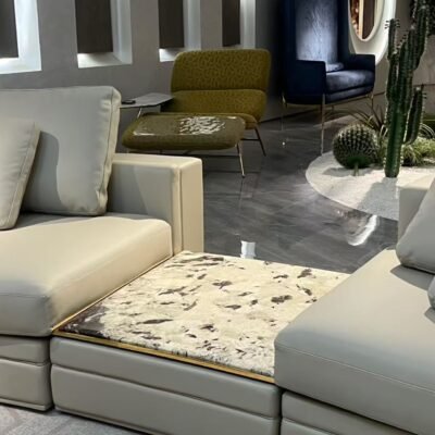 Close-up Tianshan Muxue stone accent and genuine leather surface texture on curved Babylon sofa