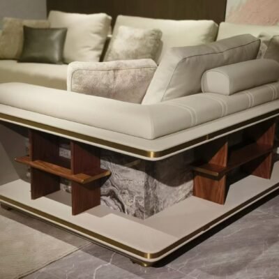 Close-up brushed gold frame and Venetian brown stone slab detail on white leather sectional