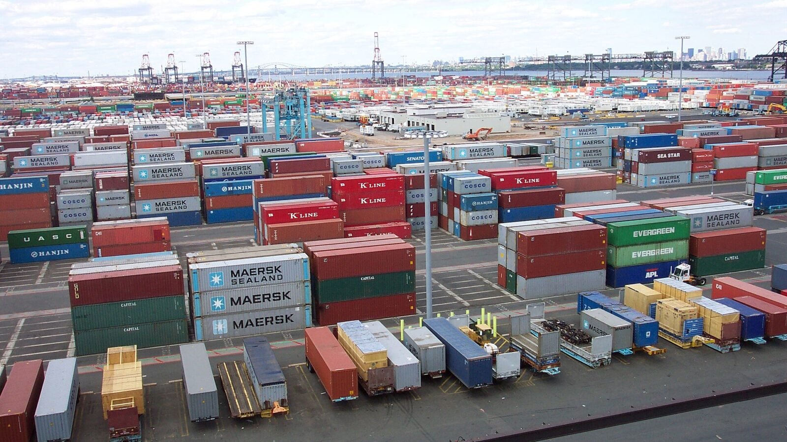 How to Import Hotel Furniture from China: A Practical Guide for Hotel Projects 3 Shipping containers at a commercial port, illustrating international furniture logistics