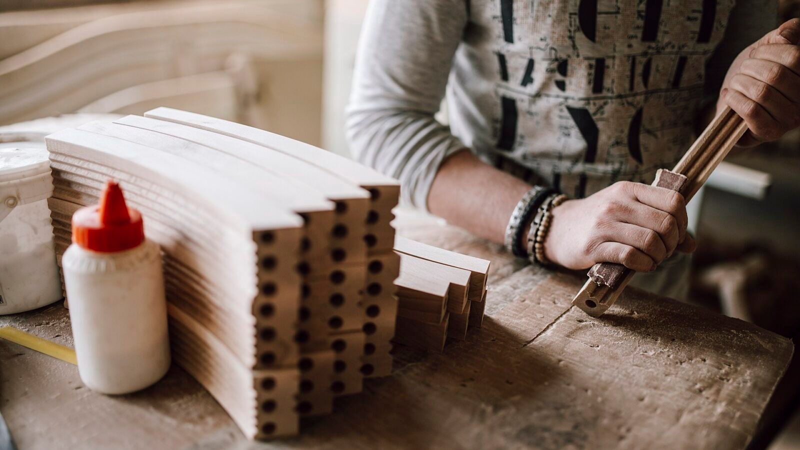 How to Import Hotel Furniture from China: A Practical Guide for Hotel Projects 2 Woodworker shaping furniture components at a workbench, illustrating furniture production